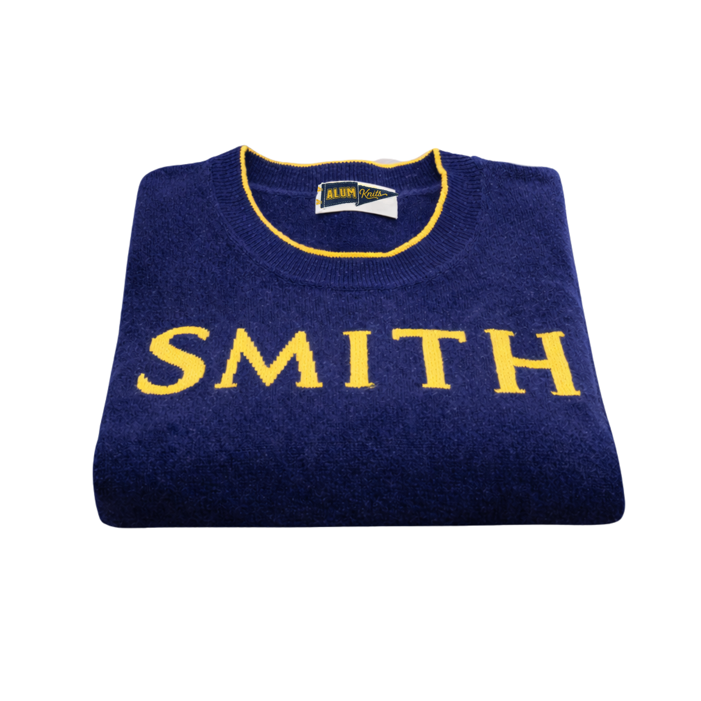 Folded navy blue sweater with 'SMITH' in yellow on a white background