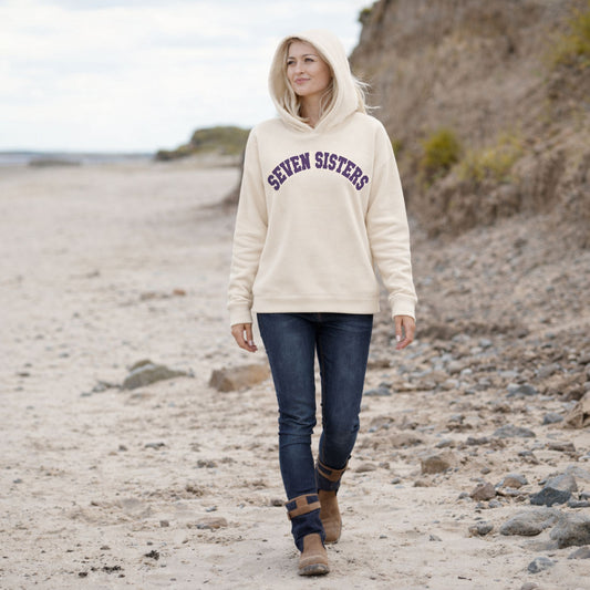 Woman wearing a 'Seven Sisters' hoodie on a beach